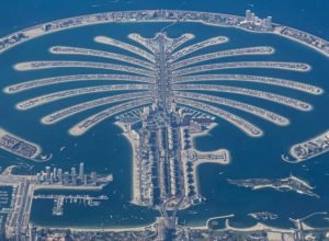 Aerial view from an airplane window of Palm Jumeirah artificial islands over the city view, on the Persian Gulf in Jumeirah, Dubai, United Arab Emirates part of the Palm Islands developments, increasing Dubai's shoreline. The islands in the archipelago were created using land reclamation. The Palm Jumeirah construction was done by a Dutch specialist dredging company, Van Oord. The islands have residential housing units, hotels, resorts, retail and dining shops, restaurants and markets in addition to the venues and recreational areas near the sandy beach. Apart from road and boat the island has a monorail transportation system. It is one of the most recognizable symbols, landmark of Dubai. Dubai, UAE on December 2023 (Photo by Nicolas Economou/NurPhoto via Getty Images)
